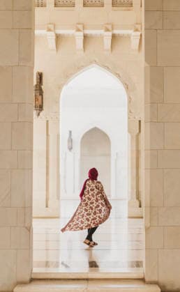 Western woman with head covering framed in archway at islamic mosque Muscat, Muscat Governorate, Oman CR_SSNF260316B-1977690-01 ,model released, Symbolfoto