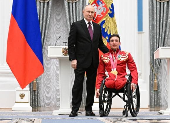 Russia Putin Paralympic Athletes 9126924 19.03.2026 Russian President Vladimir Putin poses with Paralympic champion in the men™s 10km and 20km interval start sitting para cross-country skiing Ivan Golubkov, awarded the Order of Friendship, during a state awards ceremony for the Russian medalists of the Milano Cortina 2026 Winter Paralympic Games at the Kremlin in Moscow, Russia. Sergey Bobylev Sputnik Moscow Russia  Copyright: xSergeyxBobylevx