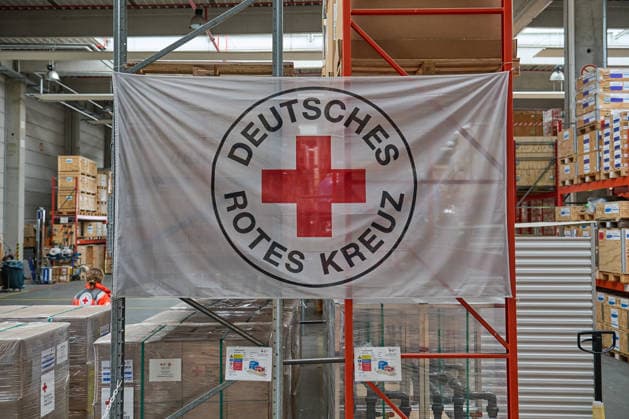Logistikzentrum mit Hilfsguetern vom Deutschen Roten Kreuz (DRK) am Flughafen Berlin-Schoenefeld (Foto vom 20.03.2026). Fast 30 Tonnen Hilfsgueter auf mehr als 80 Paletten werden fuer die vom Krieg betroffenen Menschen im Libanon verladen. In Absprache mit dem Libanesischen Roten Kreuz (LRK) kann das DRK nun bedarfsgerechte Hilfsgueter auf den Weg bringen. Die Lieferung besteht aus Zelten, Planen, Decken, Kuechensets zum Kochen, Hygienesets, die u.a. Waschpulver, Seife und Zahnpasta umfassen. Der Transport wird u.a. aus Mitteln vom Belgischen Roten Kreuz Flandern materiell und finanziell unterstuetzt. EDITORIAL USE ONLY *** Logistics center with relief supplies from the German Red Cross DRK at Berlin Schoenefeld Airport Photo from 20 03 202 Copyright: epd-bild ChristianxDitsch D26D0320DRKHilfsgueterLibanon092101