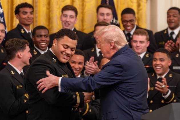 March 20, 2026, Washington, District Of Columbia, USA: Navy defensive tackle LANDON ROBINSON shows off his muscles for President DONALD TRUMP during an event in the East Room of the White House. Washington USA - ZUMAs365 20260320_znp_s365_015 Copyright: xJoeyxSussmanx