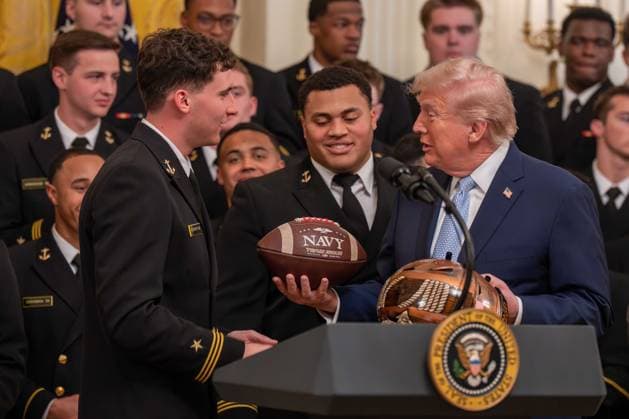 March 20, 2026, Washington, District Of Columbia, USA: President DONALD TRUMP is presented with gifts by Navy Midshipmen players BLAKE HORVATH and LANDON ROBINSON during an event in the East Room of the White House. Washington USA  - ZUMAs365 20260320_znp_s365_027 Copyright: xJoeyxSussmanx