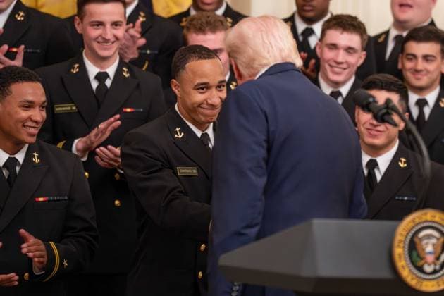 March 20, 2026, Washington, District Of Columbia, USA: President DONALD TRUMP interacts with a player on the Navy Midshipmen football team during an event in the East Room of the White House. Washington USA  - ZUMAs365 20260320_znp_s365_017 Copyright: xJoeyxSussmanx