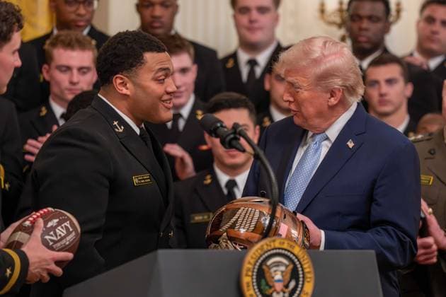 March 20, 2026, Washington, District Of Columbia, USA: President DONALD TRUMP is presented with gifts by Navy Midshipmen players BLAKE HORVATH and LANDON ROBINSON during an event in the East Room of the White House. Washington USA - ZUMAs365 20260320_znp_s365_025 Copyright: xJoeyxSussmanx