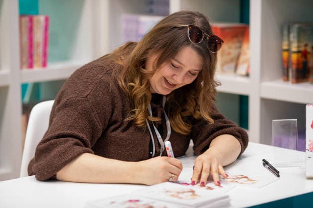Leipzig - Lesebegeisterung in Leipzig: Buchmesse lockt tausende Besucher auf das Messegelände 21.03.2026¨Leipzig, Messe-Allee (Leipziger Messe)¨Fotografin: EHL Media Julia Tuncel Im Foto: Autorin Marie Döling signiert ihr Buch Kein Ort dieser Welt Am Samstagnachmittag zeigte sich die Leipziger Buchmesse auf dem Gelände der Leipziger Messe erneut als großer Publikumsmagnet. Am frühen Nachmittag herrschte ein deutlich erhöhtes Besucheraufkommen, zahlreiche Menschen strömten in die Hallen und durch die einzelnen Gänge. Im Verlauf des Tages nutzten tausende Literaturinteressierte die Gelegenheit, sich über Neuerscheinungen zu informieren, Lesungen zu besuchen und mit Autoren ins Gespräch zu kommen. Besonders stark frequentiert Copyright: xEHLxMedia JuliaxTuncelx 20260321_buchmesse-leipzig-jt_10