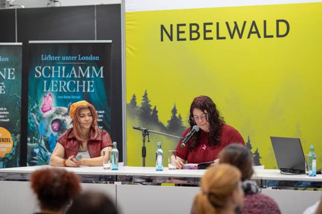 Leipzig - Lesebegeisterung in Leipzig: Buchmesse lockt tausende Besucher auf das Messegelände 21.03.2026¨Leipzig, Messe-Allee (Leipziger Messe)¨Fotografin: EHL Media Julia Tuncel Im Foto: Autorin Anne Herzel liest aus ihrem Buch Schlammlerche aus der Reihe Lichter unter London Am Samstagnachmittag zeigte sich die Leipziger Buchmesse auf dem Gelände der Leipziger Messe erneut als großer Publikumsmagnet. Am frühen Nachmittag herrschte ein deutlich erhöhtes Besucheraufkommen, zahlreiche Menschen strömten in die Hallen und durch die einzelnen Gänge. Im Verlauf des Tages nutzten tausende Literaturinteressierte die Gelegenheit, sich über Neuerscheinungen zu informieren, Lesungen zu besuchen und mit Autoren ins Gespräch zu komme Copyright: xEHLxMedia JuliaxTuncelx 20260321_buchmesse-leipzig-jt_5