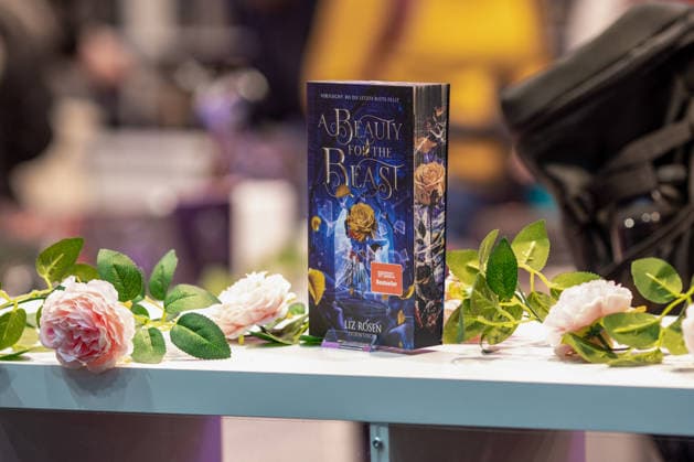 Leipzig - Lesebegeisterung in Leipzig: Buchmesse lockt tausende Besucher auf das Messegelände 21.03.2026¨Leipzig, Messe-Allee (Leipziger Messe)¨Fotografin: EHL Media Julia Tuncel Im Foto: Buch A Beauty for the Beast von Liz Rosen Am Samstagnachmittag zeigte sich die Leipziger Buchmesse auf dem Gelände der Leipziger Messe erneut als großer Publikumsmagnet. Am frühen Nachmittag herrschte ein deutlich erhöhtes Besucheraufkommen, zahlreiche Menschen strömten in die Hallen und durch die einzelnen Gänge. Im Verlauf des Tages nutzten tausende Literaturinteressierte die Gelegenheit, sich über Neuerscheinungen zu informieren, Lesungen zu besuchen und mit Autoren ins Gespräch zu kommen. Besonders stark frequentiert waren erneut die B Copyright: xEHLxMedia JuliaxTuncelx 20260321_buchmesse-leipzig-jt_8