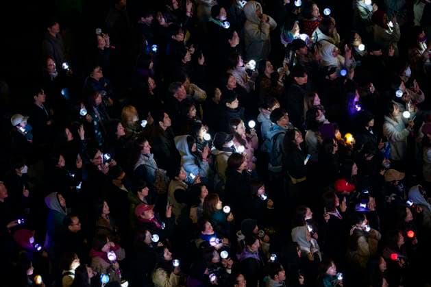 March 21, 2026, Seoul, South Korea: People hold K-pop light sticks as they watch the boy band BTS perform for the first time in four years as they return from a hiatus due to its membersÃ¢â‚¬â ¢ compulsory military service, in a free concert held on Saturday, March 21, 2026 to promote their new album ARIRANG in Gwanghwamun Square in Seoul, South Korea Seoul South Korea  - ZUMAh163 20260321_znp_h163_013 Copyright: xJintakxHanx