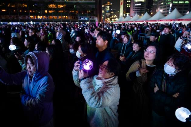March 21, 2026, Seoul, South Korea: People hold K-pop light sticks as they watch the boy band BTS perform for the first time in four years as they return from a hiatus due to its membersÃ¢â‚¬â ¢ compulsory military service, in a free concert held on Saturday, March 21, 2026 to promote their new album ARIRANG in Gwanghwamun Square in Seoul, South Korea Seoul South Korea - ZUMAh163 20260321_znp_h163_018 Copyright: xJintakxHanx