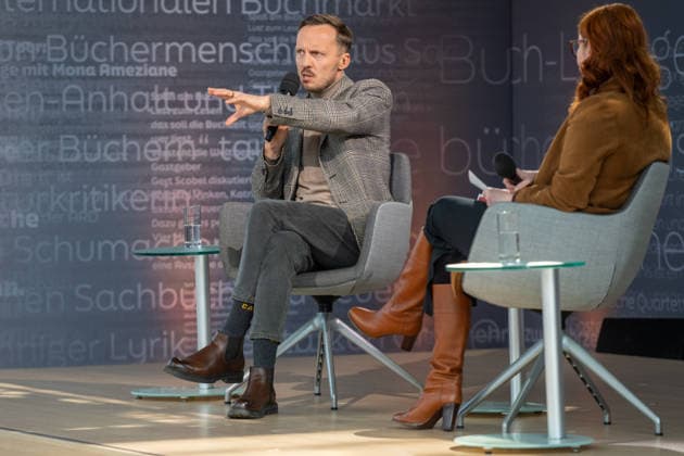Leipzig - Volle Hallen zum letzten Messetag: Abschluss auf der Leipziger Buchmesse 22.03.2026¨Leipzig, Messe-Allee (Leipziger Messe) im Foto: Michal Hvorecky mit seinem Buch Dissident auf der Bühne von ARD, ZDF und 3sat in der Glashalle ¨Am Sonntag hat die Leipziger Buchmesse noch einmal zahlreiche Besucher auf das Messegelände gelockt und einen lebendigen Abschluss des diesjährigen Events geboten. Besonders Familien, Literaturfans und Cosplay-Begeisterte nutzten den letzten Messetag, um durch die Hallen zu schlendern, Neuerscheinungen zu entdecken und Autorinnen und Autoren hautnah zu erleben. Neben gut besuchten Lesungen und Signierstunden stand vor allem der Austausch im Mittelpunkt: Gespräche über aktuelle gesellschaftli Copyright: xEHLxMedia Erik-HolmxLanghofx 20260322_buchmesse-leipzig-sonntag_69