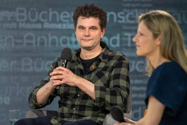 Leipzig - Volle Hallen zum letzten Messetag: Abschluss auf der Leipziger Buchmesse 22.03.2026¨Leipzig, Messe-Allee (Leipziger Messe) im Foto: Lutz van der Horst mit seinem Buch Konfetti-Blues auf der Bühne von ARD, ZDF und 3sat in der Glashalle ¨Am Sonntag hat die Leipziger Buchmesse noch einmal zahlreiche Besucher auf das Messegelände gelockt und einen lebendigen Abschluss des diesjährigen Events geboten. Besonders Familien, Literaturfans und Cosplay-Begeisterte nutzten den letzten Messetag, um durch die Hallen zu schlendern, Neuerscheinungen zu entdecken und Autorinnen und Autoren hautnah zu erleben. Neben gut besuchten Lesungen und Signierstunden stand vor allem der Austausch im Mittelpunkt: Gespräche über aktuelle gesell Copyright: xEHLxMedia Erik-HolmxLanghofx 20260322_buchmesse-leipzig-sonntag_75