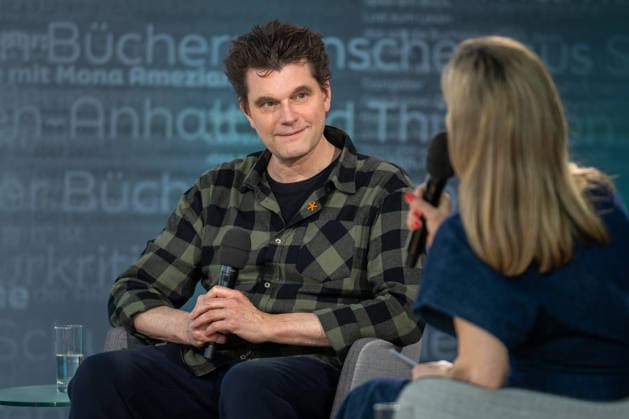 Leipzig - Volle Hallen zum letzten Messetag: Abschluss auf der Leipziger Buchmesse 22.03.2026¨Leipzig, Messe-Allee (Leipziger Messe) im Foto: Lutz van der Horst mit seinem Buch Konfetti-Blues auf der Bühne von ARD, ZDF und 3sat in der Glashalle ¨Am Sonntag hat die Leipziger Buchmesse noch einmal zahlreiche Besucher auf das Messegelände gelockt und einen lebendigen Abschluss des diesjährigen Events geboten. Besonders Familien, Literaturfans und Cosplay-Begeisterte nutzten den letzten Messetag, um durch die Hallen zu schlendern, Neuerscheinungen zu entdecken und Autorinnen und Autoren hautnah zu erleben. Neben gut besuchten Lesungen und Signierstunden stand vor allem der Austausch im Mittelpunkt: Gespräche über aktuelle gesell Copyright: xEHLxMedia Erik-HolmxLanghofx 20260322_buchmesse-leipzig-sonntag_77