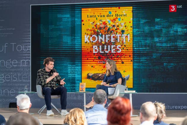 Leipzig - Volle Hallen zum letzten Messetag: Abschluss auf der Leipziger Buchmesse 22.03.2026¨Leipzig, Messe-Allee (Leipziger Messe) im Foto: Lutz van der Horst mit seinem Buch Konfetti-Blues auf der Bühne von ARD, ZDF und 3sat in der Glashalle ¨Am Sonntag hat die Leipziger Buchmesse noch einmal zahlreiche Besucher auf das Messegelände gelockt und einen lebendigen Abschluss des diesjährigen Events geboten. Besonders Familien, Literaturfans und Cosplay-Begeisterte nutzten den letzten Messetag, um durch die Hallen zu schlendern, Neuerscheinungen zu entdecken und Autorinnen und Autoren hautnah zu erleben. Neben gut besuchten Lesungen und Signierstunden stand vor allem der Austausch im Mittelpunkt: Gespräche über aktuelle gesell Copyright: xEHLxMedia Erik-HolmxLanghofx 20260322_buchmesse-leipzig-sonntag_88