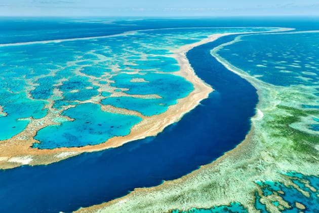 Luftaufnahme der lebhaften Korallenformationen des Great Barrier Reef. Aerial view of the Great Barrier Reef, Australia, showcasing its vibrant coral formations and clear turquoise waters, a vital ecosystem facing climate change threats. (License=RF) Copyright: xZoonar.com MarcoxBriviox 24799924