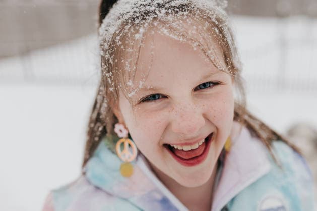 Close up of young girl smiling while she plays in snow on winter day Sioux Falls, South Dakota, United States CR_ASWE26031894-1981815-01 ,model released, Symbolfoto
