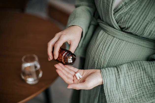 Pregnant woman taking prenatal vitamins and supplements indoors model released, Symbolfoto, HDF00271