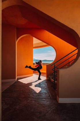 Energetic teenager dancing in sunny modern architecture with terracotta walls model released, Symbolfoto, AAF00511