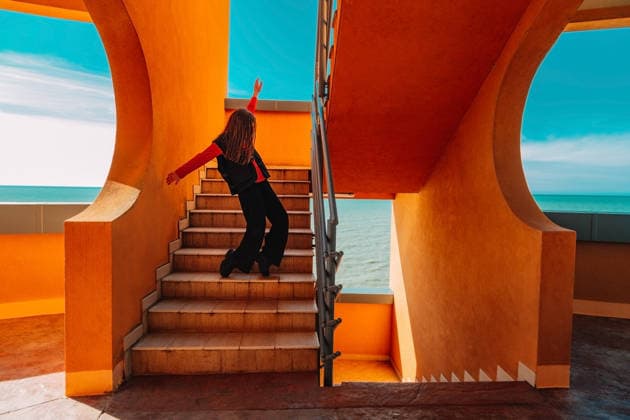 Teenager dancing energetically on stairs near terracotta walls and sea model released, Symbolfoto, AAF00514