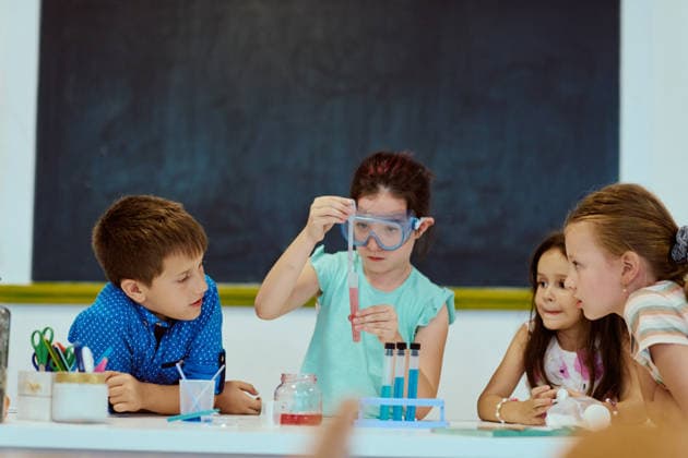 Kinder, die in einem Klassenzimmer ein wissenschaftliches Experiment durchführen, Schutzbrillen tragen und gemeinsam lernen Four children collaborate on a hands-on classroom science experiment, observing colorful liquids in test tubes while wearing safety goggles. Scene emphasizes STEM learning, curiosity, teamwork, discovery and elementary education. (License=RF) ,model released, Symbolfoto Copyright: xZoonar.com BENISxARAPOVICx 24814856 ,model released, Symbolfoto ,property released