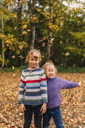 Children playing and tossing leaves in autumn forest outdoors model released, Symbolfoto, NASF00185