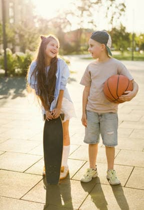 Two kids playing with skateboard and basketball at park in summer model released, Symbolfoto, ONAF01188