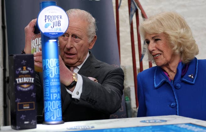 King Charles and Queen Camilla visit Cornwall, UK, 24 March 2026 Britain s Queen Camilla reacts as King Charles III pulls a pint of St Austell Brewery s Proper Job IPA 0.5%, during a visit to the The Market Hall in St Austell, south-west England on March 24, 2026., Credit:ADRIAN DENNIS Avalon United Kingdom, Cornwall  Copyright: xADRIANxDENNISx xAvalonx 1085920150