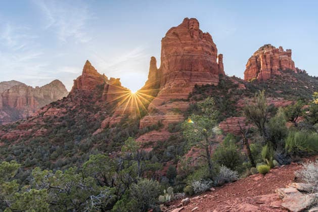 Creative Highlights World Starburst sun setting behind red rock landscape Sedona, Arizona, United States CR_MALI260324A-1987126-01