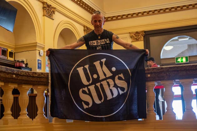 Scarborough Punk Festival 2026, UK - 29 Mar 2026 A fan of the UK Subs poses for a photo with his flag before the concert during the festival in Scarborough. Hundreds of punk rock fans gathered in Scarborough Spa in Yorkshire county, England for the two days long punk rock festival. Scarborough United Kingdom Copyright: xKrisztianxElekx xSOPAxImagesx SSS_20260329_PUNK_FEST_0011005223