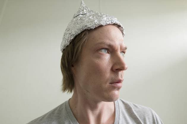 Porträt eines jungen gutaussehenden Mannes mit Alufolienhut als Konzept der Verschwörungstheorie im Schlafzimmer zu Hause Portrait of young handsome man wearing tin foil hat as conspiracy theory concept in the bedroom at home Copyright: imageBROKER TonixRantala ibxiqx16896501.jpg ,model released, Symbolfoto ,property released