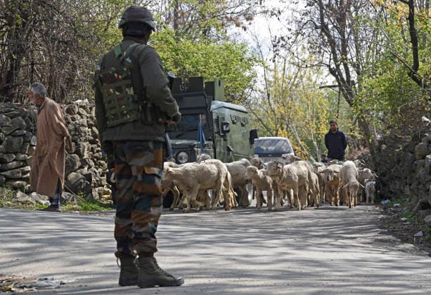 April 1, 2026, Srinagar, Jammu And Kashmir, India: A shepherd walks with their herd of sheep as army jawan stands guard near the site of gunbattle at Arhama village in Central Kashmir s Ganderbal district.A militant has been killed in an ongoing anti-militant operation in central Kashmirs Ganderbal district, the Army said on Wednesday Srinagar India  - ZUMAz120 20260401_zip_z120_005 Copyright: xBasitxZargarx