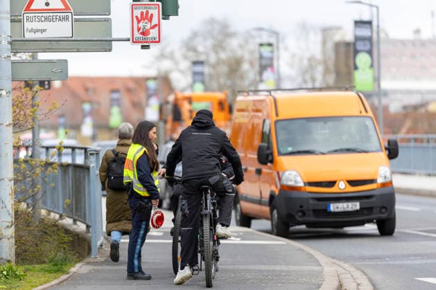 Eine Polizeibeamtin hält zwei Fahrradfahrer an, die entgegen der vorgeschriebenen Fahrtrichtung über eine Brücke fahren wollten. *** A police officer stops two cyclists who were trying to cross a bridge against the prescribed direction of travel Copyright: HMBxMedia xHeikoxBecker