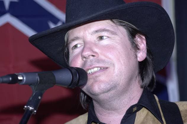 David Allan Coe singt mit Mikrofon und Cowboyhut vor einer Flagge der Konföderierten David Allan Coe singing with a microphone and cowboy hat in front of a Confederate flag Copyright: imageBROKER GamrothxJoerg ibliqx16974826.jpg