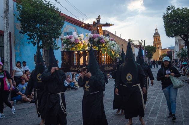Hooded penitents carry a religious image and take a vow of silence as taking part during the procession of silence for Holy Week celebrations in Temple of Santa Cruz, celebrating 60 years of tradition. As Easter approaches, honors one of the solemn religious traditions, the funeral march, know as Silence Procession. on April 3, 2026 in Queretaro, Mexico. Queretaro Mexico  - ZUMAe321 20260403_zia_e321_102 Copyright: xJosexCarrerax