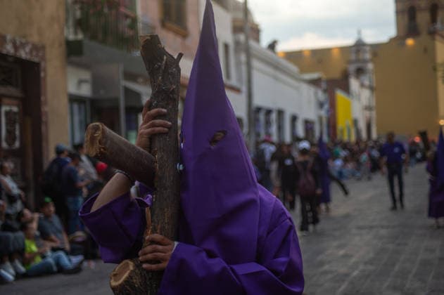 A Hooded penitent carry a wooden cross and takes a vow of silence as taking part during the procession of silence for Holy Week celebrations in Temple of Santa Cruz, celebrating 60 years of tradition. As Easter approaches, honors one of the solemn religious traditions, the funeral march, know as Silence Procession. on April 3, 2026 in Queretaro, Mexico. Queretaro Mexico  - ZUMAe321 20260403_zia_e321_110 Copyright: xJosexCarrerax