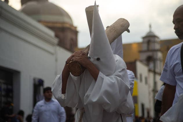 A Hooded penitent carry a wooden cross and takes a vow of silence as taking part during the procession of silence for Holy Week celebrations in Temple of Santa Cruz, celebrating 60 years of tradition. As Easter approaches, honors one of the solemn religious traditions, the funeral march, know as Silence Procession. on April 3, 2026 in Queretaro, Mexico. Queretaro Mexico - ZUMAe321 20260403_zia_e321_113 Copyright: xJosexCarrerax