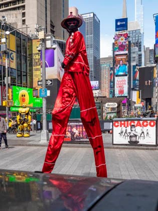 April 4, 2026, New York, New York, USA: Mystery man in red on stilts walking around Times Square.looking down on New Yorkers and tourists. Wearing an.asian outfit, red glasses and black face covering. New York USA - ZUMAh156 20260404_znp_h156_010 Copyright: xMiloxHessx