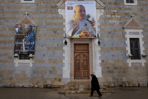 News Bilder des Tages April 5, 2026, Qlayaa, Lebanon: A woman walks beneath a sign of Father Pierre Al-Rahi to attend an Easter Sunday Mass at Saint Georges Church at Qlayaa, Lebanon on April 5, 2026. Father Pierre was killed last month by an Israeli military attack, when he tried to help people wounded by a previous Israeli attack. Qlayaa Lebanon - ZUMAc244 20260405_zip_c244_009 Copyright: xDanielxCardex