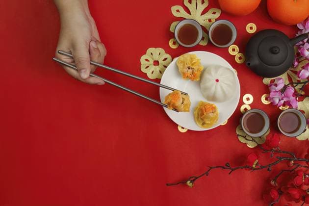 IMAGO Creative, Food, Dumplings Eine Hand, die mit Essstäbchen Knödel auf festlichem rotem Hintergrund aufhebt, symbolisiert die Traditionen und Freude des chinesischen Neujahrs A hand using chopsticks to pick up dumplings on a festive red background, symbolizing Chinese New Year traditions and joy Copyright: imageBROKER WORAWEExMEEPIAN ibxiqx17171159.jpg