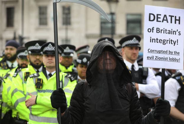 News Bilder des Tages #2 Defend Our Juries Supporters hold signs In Support Of Palestine Action in London - 11 Apr 2026 A protester dressed as the grim reaper by police officers holds a sign saying ‘Death of Britain’s Integrity - Corrupted by the Evil Zionist Lobby’’ during the protest. Following the ruling by a panel of judges at the judicial review reporting earlier this year that found the government’s proscription of pro-Palestinian direct action group Palestine Action as unlawful over 500 supporters of Defend Our Juries sat in Trafalgar Square holding signs saying, I oppose genocide. I support Palestine Action . The government are due to appeal the ruling and until that has reached a conclusion support for Palestine Action is still technically against the l Copyright: xMartinxPopex xSOPAxImagesx MPOPE_A726621
