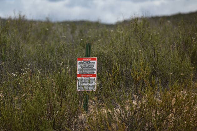April 12, 2026, Tecate, Baja California, Mexico: A warning sign on the US-side of the border viewed from Tecate, Mexico by the US Department of Defense, about arrest if territory is trespassed during a â€oeceremony†rally against the destruction of the Kuchamaa Mountain left by the construction of a new border wall at the US-Mexico Border in Tecate, Baja California, Mexico on Sunday, April 12, 2026. Tecate Mexico - ZUMAm180 20260412_zip_m180_004 Copyright: xCarlosxA.xMorenox