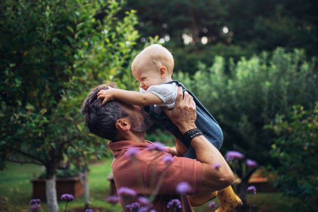 Father playing with baby daughter while spending time together in garden. Father playing with baby daughter while spending time together in the garden. model released