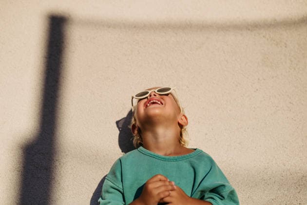 Smiling blond child wearing round sunglasses in warm sunlight. Smiling blond child wearing round sunglasses in warm sunlight. Summer season. model released