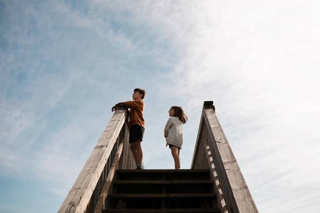 Two young children standing at the top of wooden outdoor stairs Calgary, Alberta, Canada CR_AMST26041009-1892967-01 ,model released, Symbolfoto ,property released