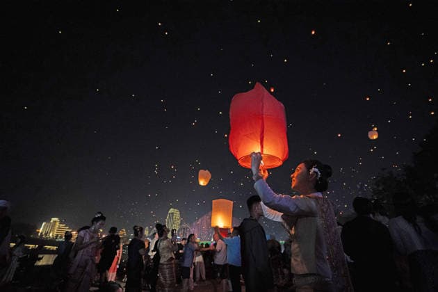 (260413) -- JINGHONG, April 13, 2026 -- People fly Kongming lanterns, a kind of small hot-air paper balloon, by the Lancang River in Jinghong City, Xishuangbanna Dai Autonomous Prefecture, southwest China s Yunnan Province, April 13, 2026. ) CHINA-YUNNAN-JINGHONG-KONGMING LANTERN (CN) JiangxWenyao 