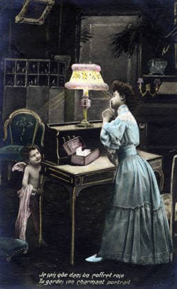 Secret of Love A young woman signals to a little Cupid hiding behind a desk not to reveal her secret She keeps a portrait of her lover in a box Postcard from the early 20th century RECORD DATE NOT STATED  Copyright: x HJL Opale.photox