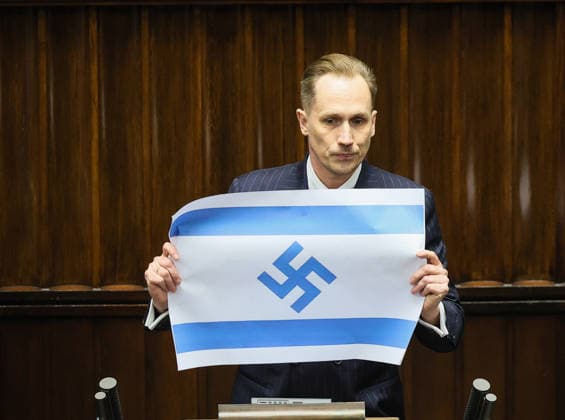 Polish MP present an Israeli flag adorned with swastika Photo: Adam Burakowski East News Deputy from ultra right-wing party Konfederacja (Polish from Confederation) Konrad Berkowicz displays an Israeli flag where David s star has been replaced with swastika as he delivers his remarks during the session of the Sejm (lower chamber of Polish Parliament) on April 14, 2026 in Warsaw, Poland. In his speech Berkowicz accused Israel and IDF of war crimes and genocide. EN_01675763_0091 
