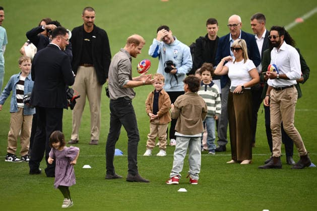 HARRY AND MEGHAN AUSTRALIA VISIT, Prince Harry the Duke of Sussex during plays with an AFL footy during a visit with the Movember Foundation at the Western Bulldogs headquarters, Whitten Oval in Melbourne, Wednesday, April 15, 2026. ( NO ARCHIVING MELBOURNE VICTORIA AUSTRALIA  Copyright: xJOELxCARRETTx 20260415195203973142