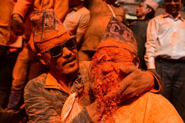 April 15, 2026, Bhaktapur, Bagmati, Nepal: Nepali revelers apply vermillion powder on each other during Sindoor Jatra, also known as Bhuyu Sinha, as part of the Biska Jatra celebrations marking the Nepali New Year 2082 on April 15, 2026. Observed on the 2nd day of Baisakh, the festival brings devotees to the temple square where 32 ceremonial palanquins carrying local deities are assembled. Participants, covered in orange powder, take part in the procession accompanied by traditional music, singing, and dancing. Bhaktapur Nepal - ZUMAs330 20260415_zsp_s330_003 Copyright: xSafalxPrakashxShresthax
