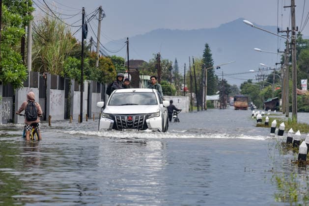 April 15, 2026, Bandung Regency, West Java, Indonesia: Residents use a car to cross the flooding in Sapan, Bandung Regency, Indonesia. Heavy rains hit Bandung on Saturday, April 11, 2026, submerging hundreds of homes, factories, and access roads in the regency to a depth of 40 to 60 centimeters. The floodwaters have not receded for five days. Bandung Regency Indonesia  - ZUMAr272 20260415_zip_r272_025 Copyright: xDimasxRachmatsyahx