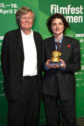 David Hare and Daisy Bevan at the presentation of the Bremen Film Prize of the Sparkasse for Vanessa Redgrave at the 11 Filmfest Bremen in the large hall of the Theater am Goetheplatz Bremen, 15 04 2026 Foto:xC.xNiehausx xFuturexImagex filmpreis_6418