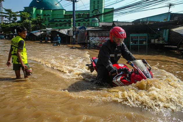 April 16, 2026, Bandung Regency, Java, Indonesia: A man rides his motorcycle through floodwaters in Dayeuhkolot, Bandung Regency, West Java, Indonesia, on April 16, 2026. Flooding caused by the overflowing Citarum River following heavy rain has affected parts of the regency, including Dayeuhkolot, Bojongsoang, and Banjaran, since April 10, with water levels ranging from 20 to 150 centimeters. Bandung Regency Indonesia  - ZUMAp283 20260416_zip_p283_009 Copyright: xClaudioxPramanax